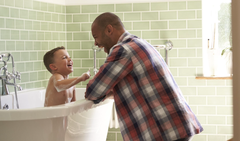 Father and son at home using hot water