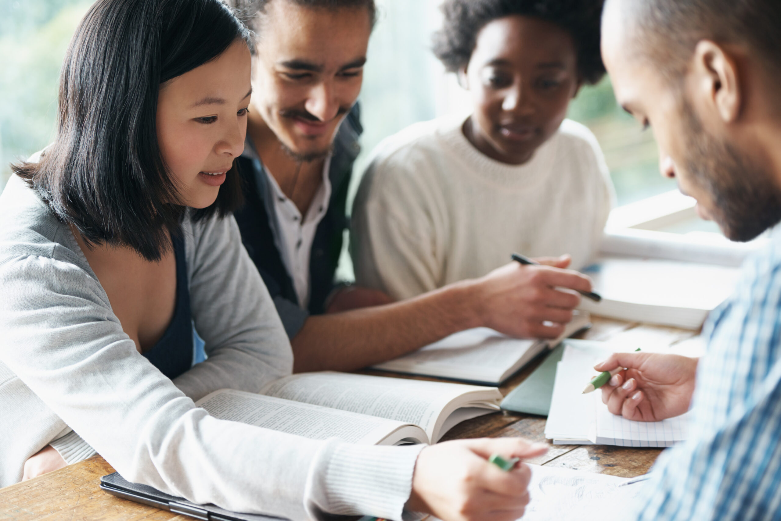 A group of college students sitting together and studying.